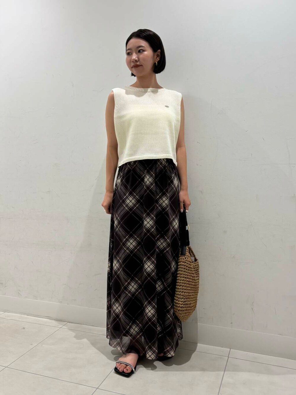 イエロー系のトートバッグ、ブラック系のキャミソール、ブラック系のサンダルを着用したレディースの夏コーディネートの2枚目の写真