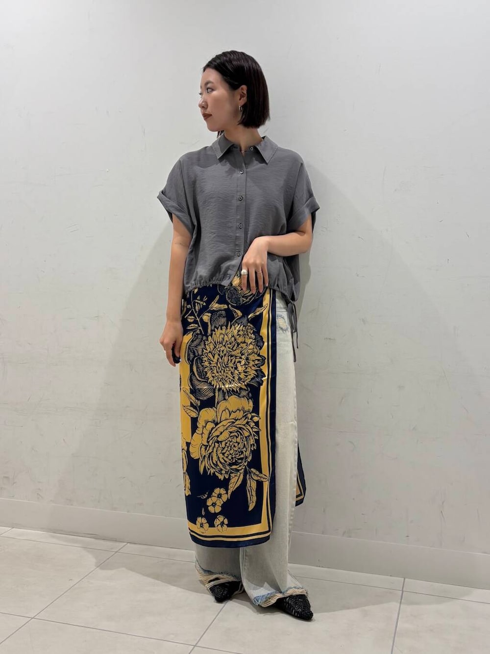 ブラック系のサンダル、グレー系のシャツ/ブラウス、ブルー系のデニムパンツを着用したレディースの夏コーディネートの2枚目の写真