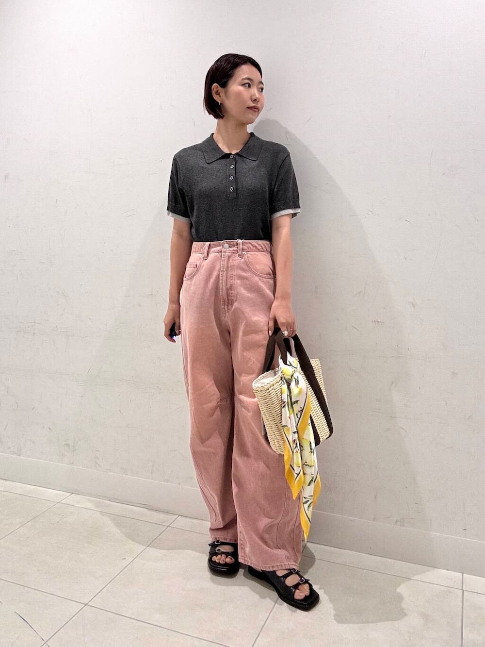 ホワイト系のハンドバッグ、ピンク系のデニムパンツ、ブラック系のサンダルを着用したレディースの夏コーディネートの3枚目の写真