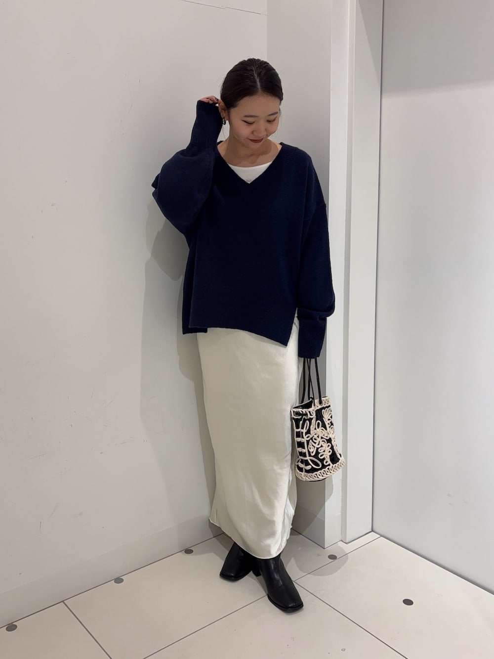 ブルー系のニット/セーター、ホワイト系のTシャツ/カットソー、ホワイト系のスカートを着用したレディースの冬コーディネートの2枚目の写真