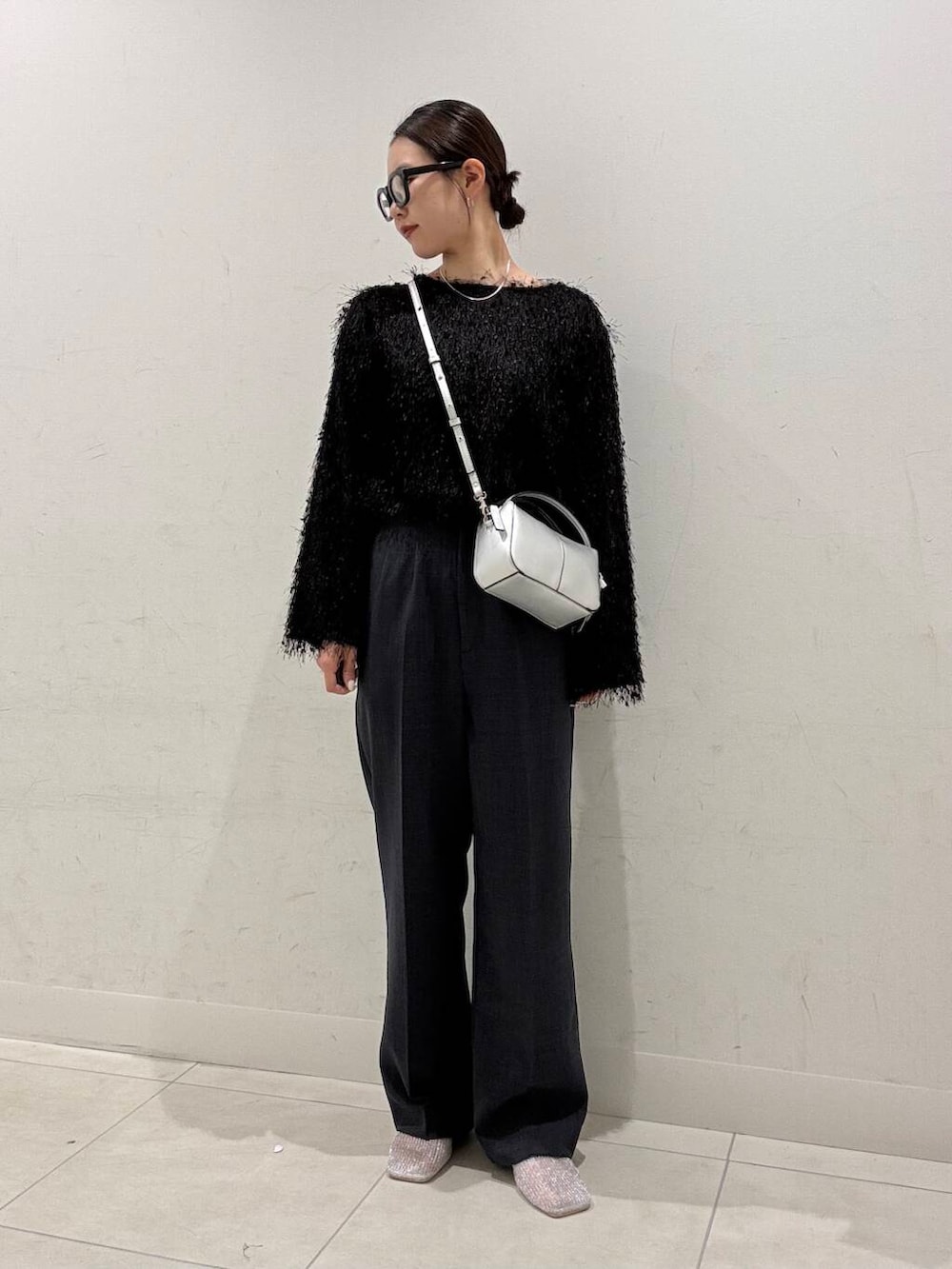 シルバー系のハンドバッグ、シルバー系のパンプス、ブラック系のTシャツ/カットソーを着用したレディースの春コーディネートの3枚目の写真