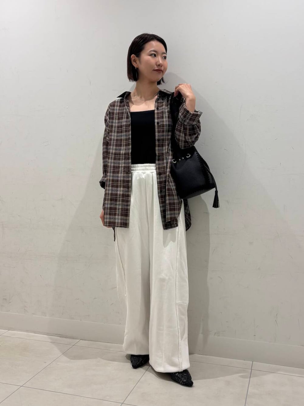 ブラック系のキャミソール、ブラック系のサンダル、ホワイト系のスウェットパンツを着用したレディースの夏コーディネートの2枚目の写真