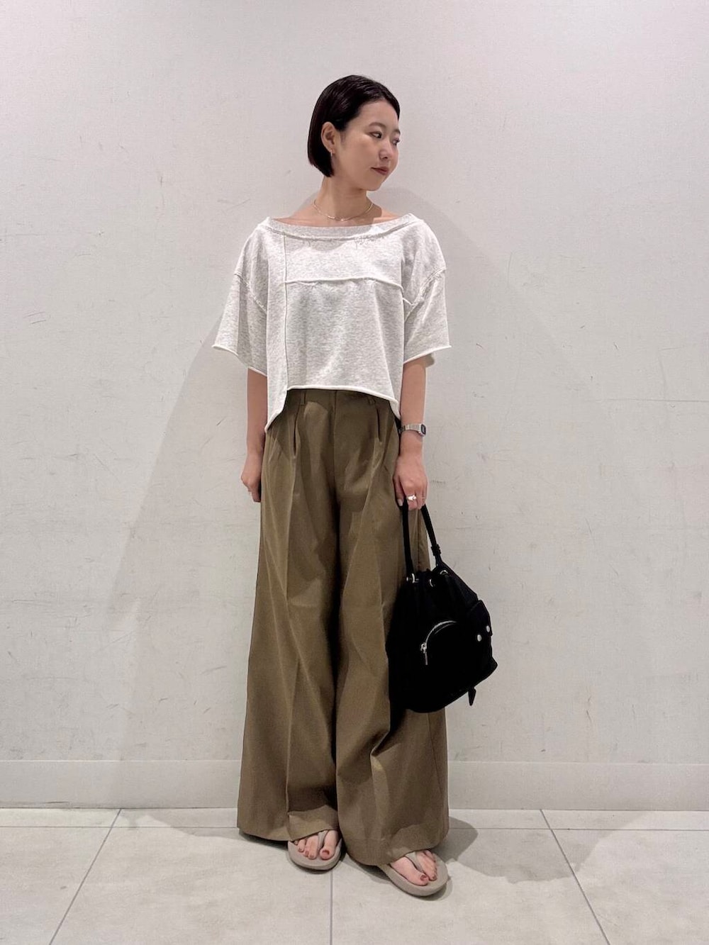 ブラック系のショルダーバッグ、ベージュ系のその他パンツ、ベージュ系のTシャツ/カットソーを着用したレディースの夏コーディネートの2枚目の写真