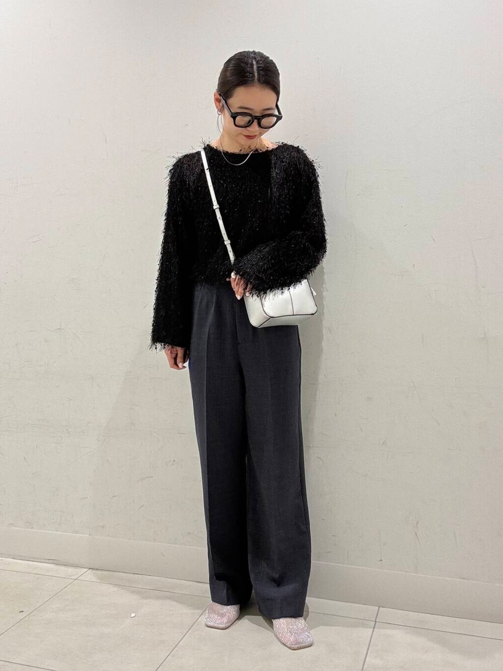 シルバー系のハンドバッグ、シルバー系のパンプス、ブラック系のTシャツ/カットソーを着用したレディースの春コーディネートの2枚目の写真