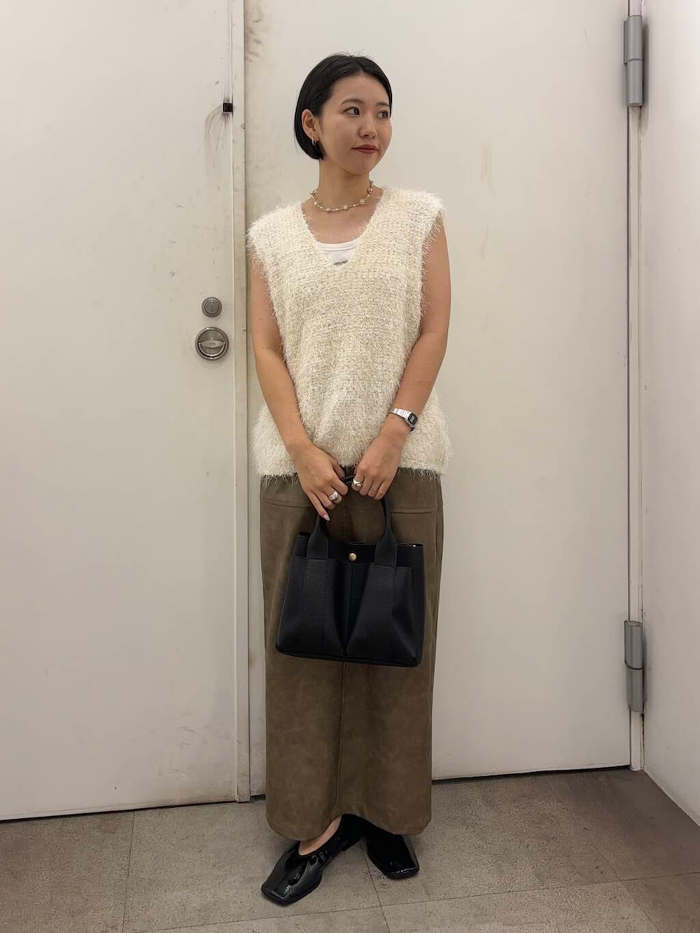 ブラック系のトートバッグ、レッド系のバレエシューズ、グリーン系のスカートを着用したレディースの秋コーディネートの3枚目の写真