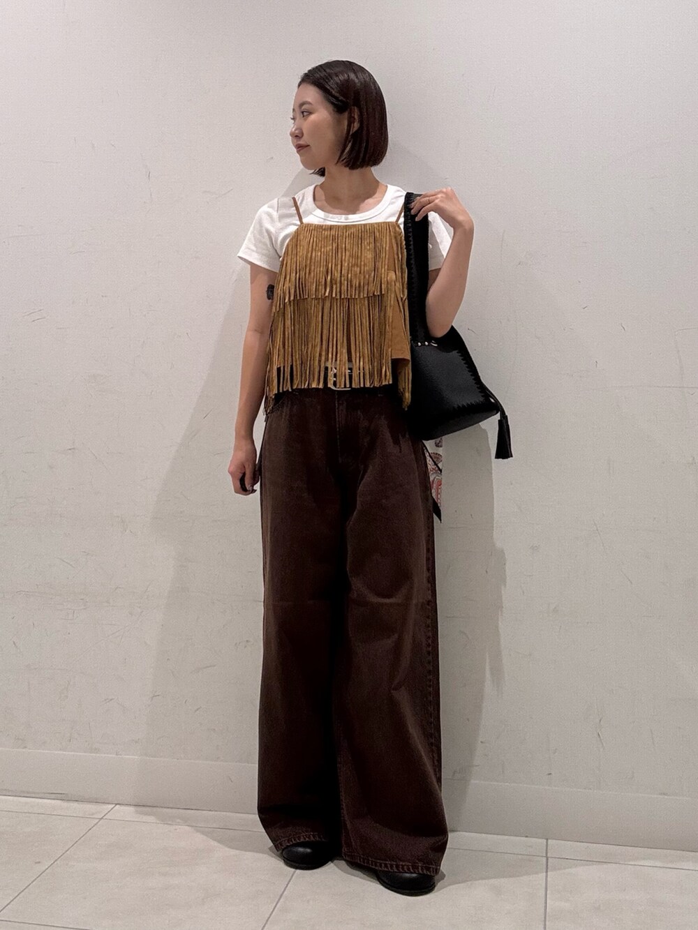 ホワイト系のTシャツ/カットソー、イエロー系のキャミソール、ブラウン系のデニムパンツを着用したレディースの夏コーディネートの3枚目の写真