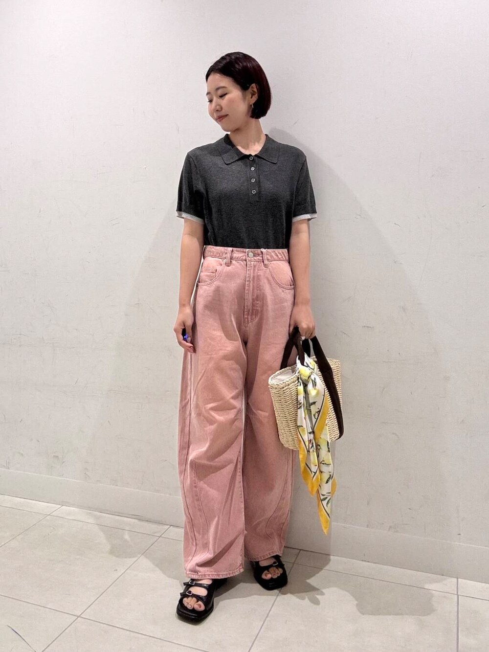 ホワイト系のハンドバッグ、ピンク系のデニムパンツ、ブラック系のサンダルを着用したレディースの夏コーディネートの2枚目の写真