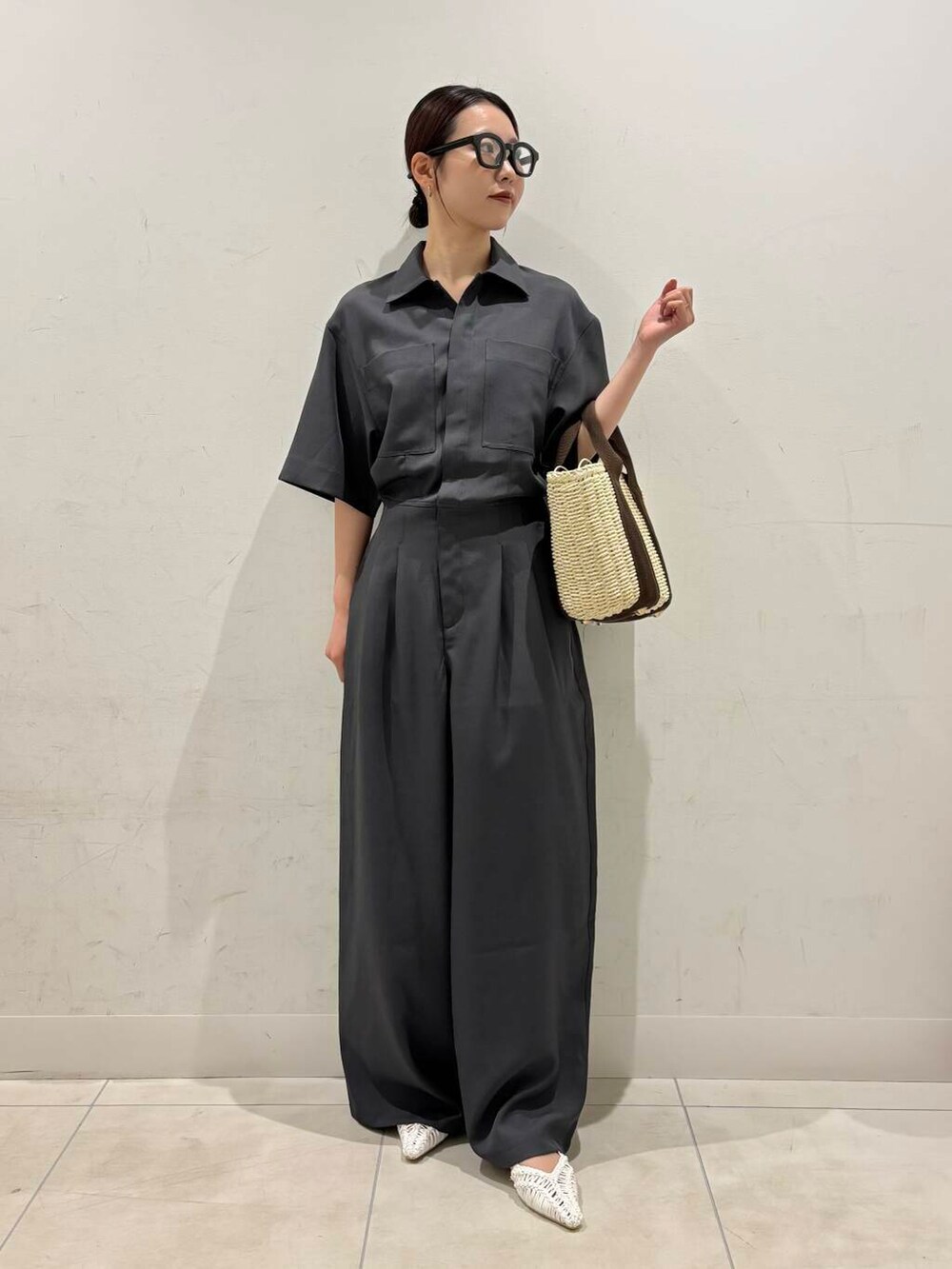 ホワイト系のハンドバッグ、ホワイト系のサンダル、グレー系のサロペット/オーバーオールを着用したレディースの春コーディネートの3枚目の写真