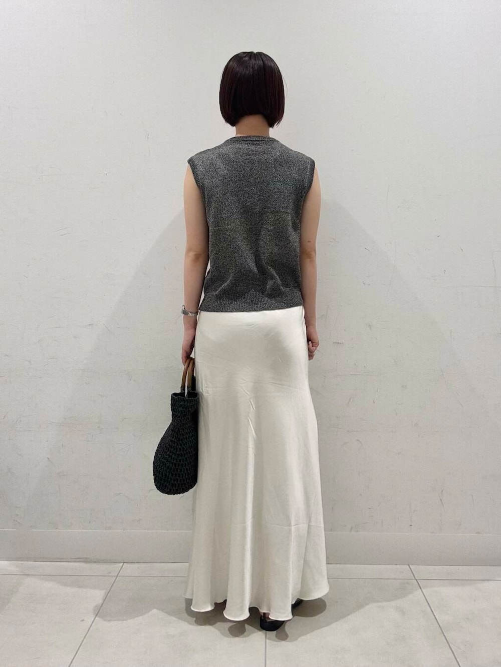 ホワイト系のスカート、ブラック系のトートバッグ、ブラック系のサンダルを着用したレディースの夏コーディネートの4枚目の写真