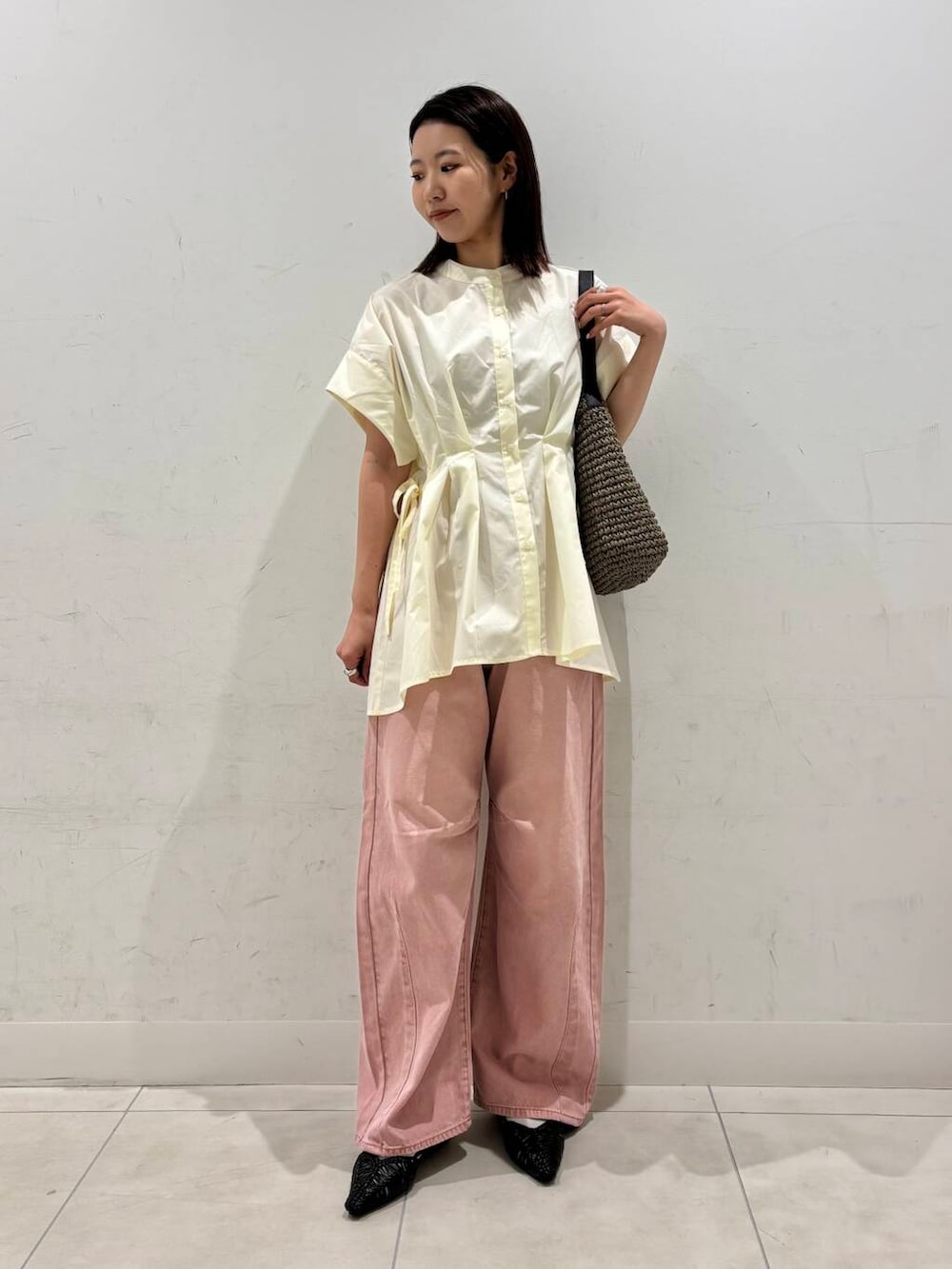 グレー系のトートバッグ、ブラック系のサンダル、ピンク系のデニムパンツを着用したレディースの春コーディネートの3枚目の写真