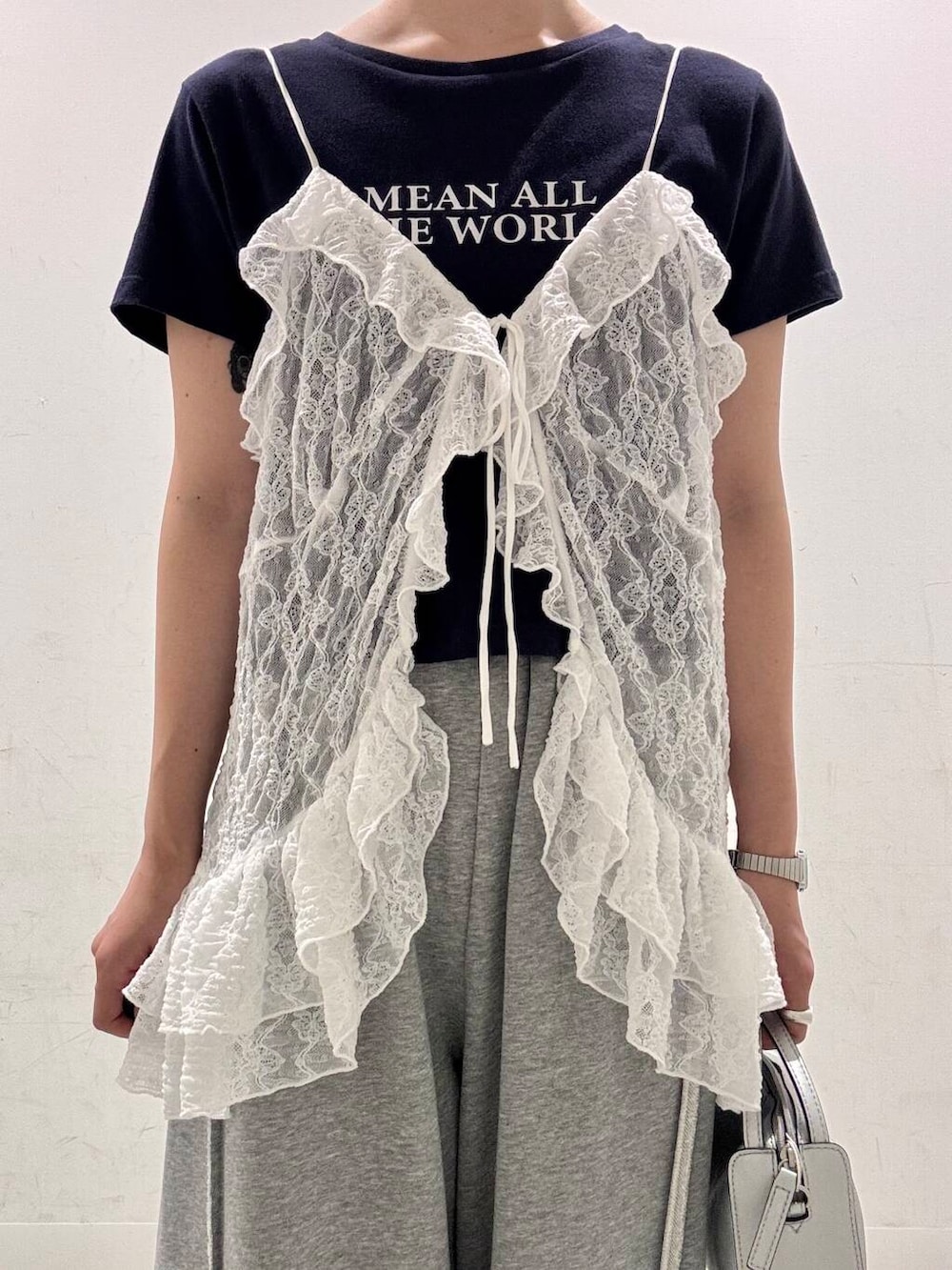 シルバー系のハンドバッグ、ブラック系のサンダル、その他のTシャツ/カットソーを着用したレディースの夏コーディネートの4枚目の写真