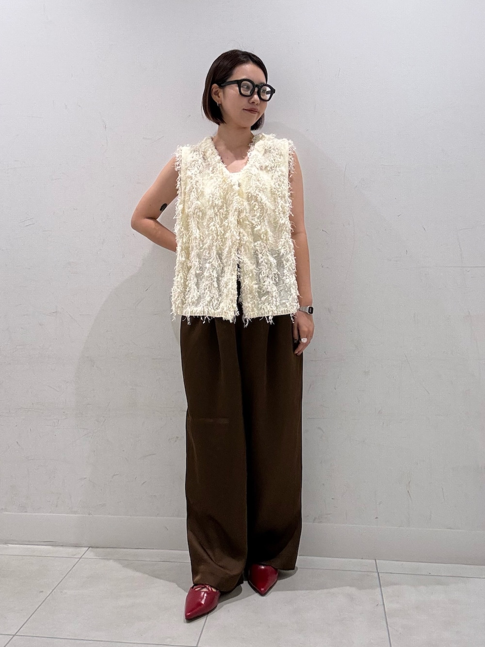 ホワイト系のベスト、ブラウン系のその他パンツ、レッド系のその他シューズを着用したレディースの夏コーディネートの3枚目の写真