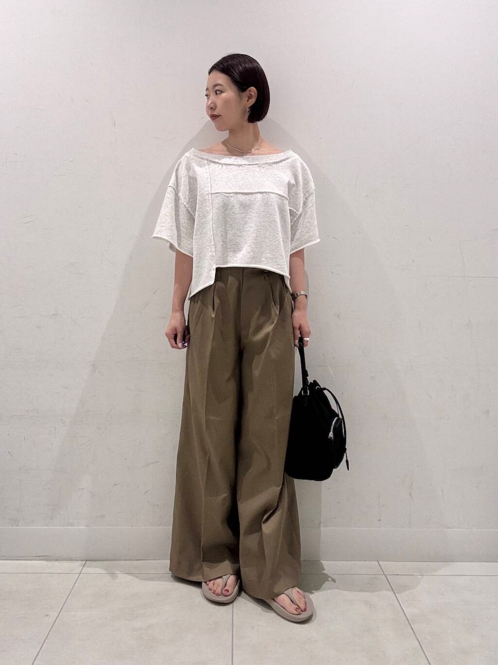 ブラック系のショルダーバッグ、ベージュ系のその他パンツ、ベージュ系のTシャツ/カットソーを着用したレディースの夏コーディネートの3枚目の写真