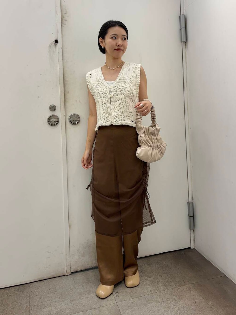 イエロー系のその他シューズ、ホワイト系のハンドバッグ、ブラウン系のその他パンツを着用したレディースの秋コーディネートの3枚目の写真