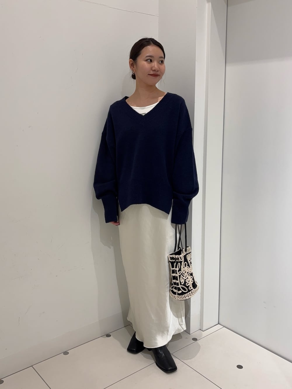 ブルー系のニット/セーター、ホワイト系のTシャツ/カットソー、ホワイト系のスカートを着用したレディースの冬コーディネートの3枚目の写真