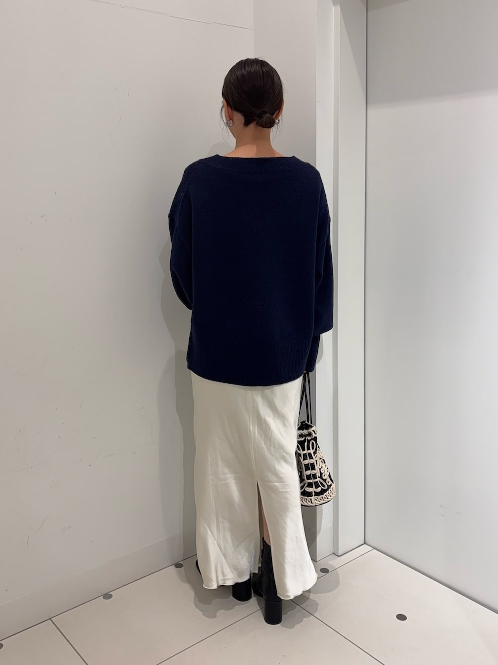 ブルー系のニット/セーター、ホワイト系のTシャツ/カットソー、ホワイト系のスカートを着用したレディースの冬コーディネートの4枚目の写真