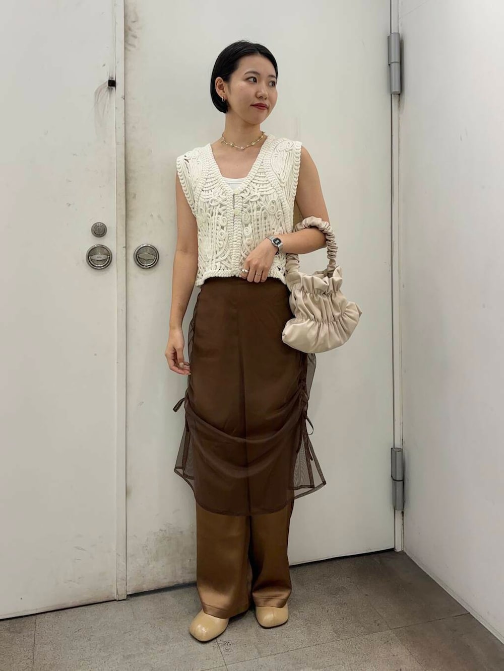 イエロー系のその他シューズ、ホワイト系のハンドバッグ、ブラウン系のその他パンツを着用したレディースの秋コーディネートの2枚目の写真