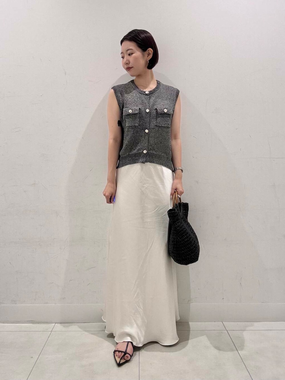 ホワイト系のスカート、ブラック系のトートバッグ、ブラック系のサンダルを着用したレディースの夏コーディネートの3枚目の写真