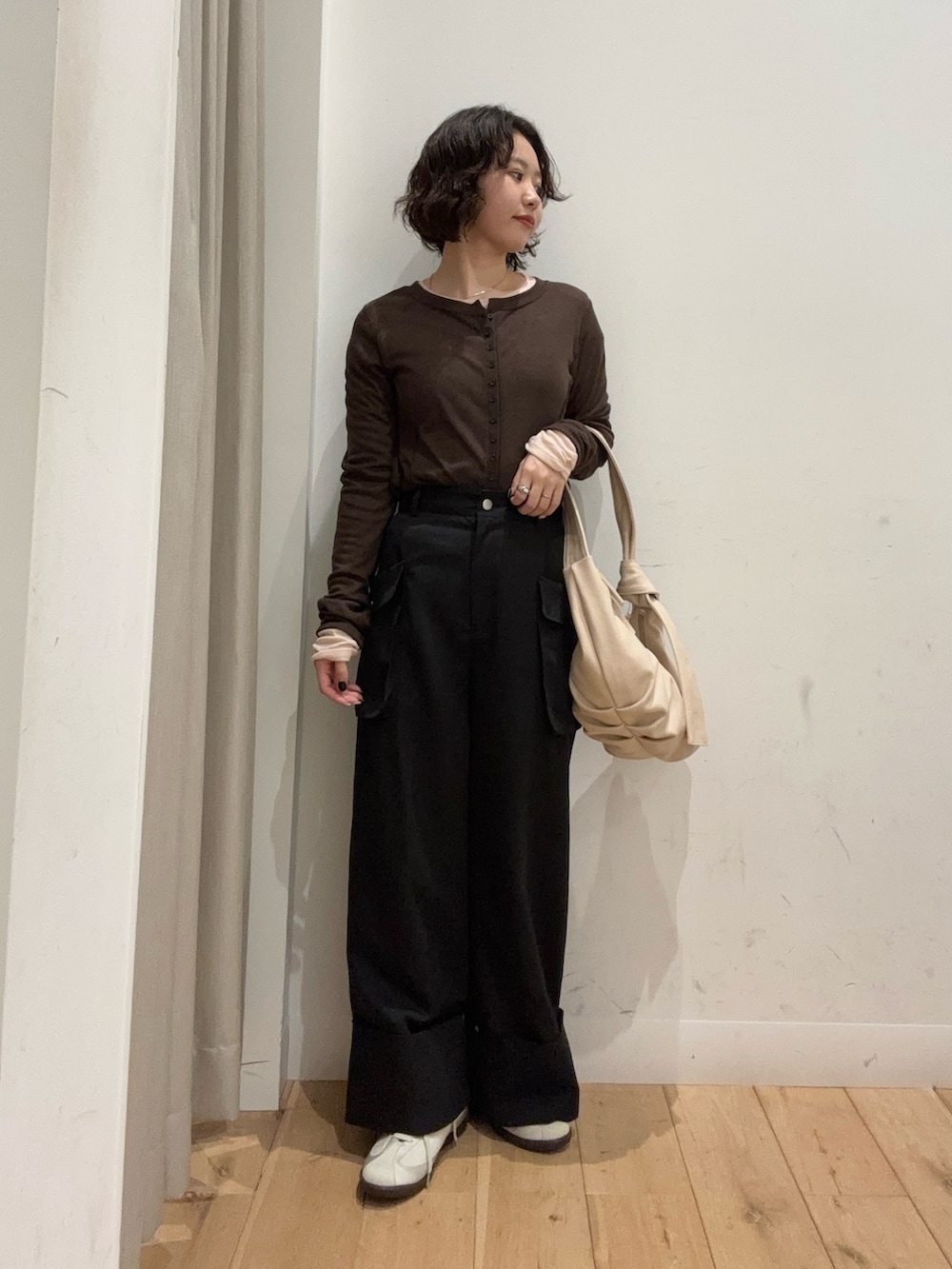 ブラウン系のTシャツ/カットソー、ブラック系のその他パンツ、ベージュ系のショルダーバッグを着用したレディースの冬コーディネートの3枚目の写真