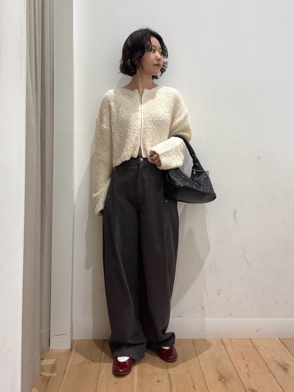 ホワイト系のカーディガン/ボレロ、グレー系のその他パンツ、ブラック系のハンドバッグを着用したレディースの冬コーディネートの3枚目の写真