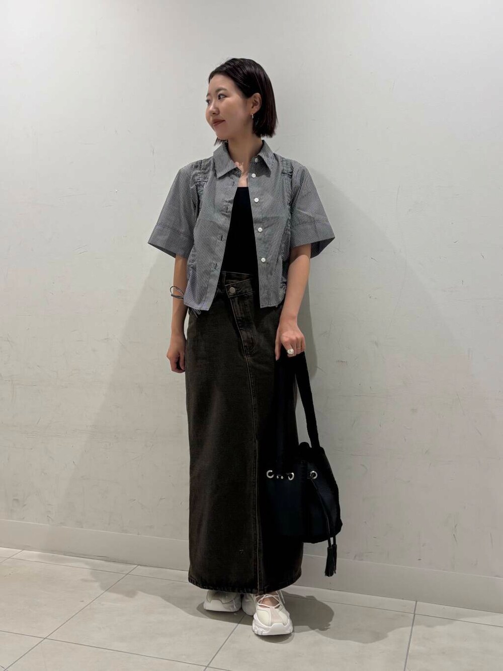 ブラック系のキャミソール、ホワイト系のスニーカー、グレー系のシャツ/ブラウスを着用したレディースの夏コーディネートの3枚目の写真