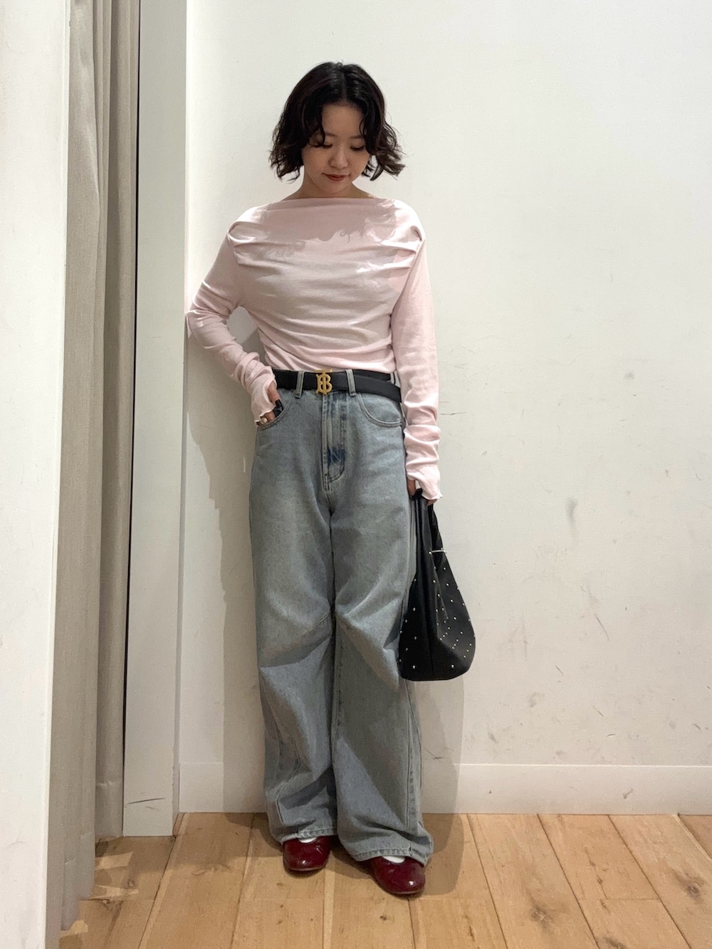 ピンク系のTシャツ/カットソー、ブルー系のデニムパンツ、ブラック系のハンドバッグを着用したレディースの冬コーディネートの2枚目の写真