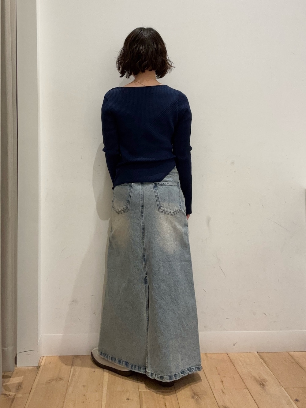 ブルー系のニット/セーター、ブルー系のスカート、ベージュ系のショルダーバッグを着用したレディースの冬コーディネートの3枚目の写真