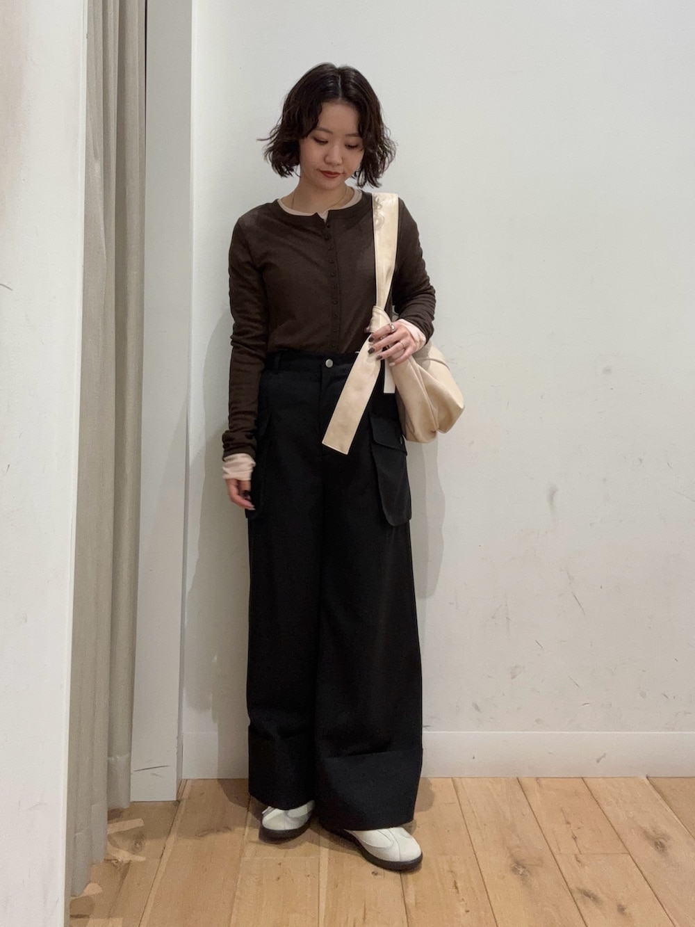 ブラウン系のTシャツ/カットソー、ブラック系のその他パンツ、ベージュ系のショルダーバッグを着用したレディースの冬コーディネートの2枚目の写真