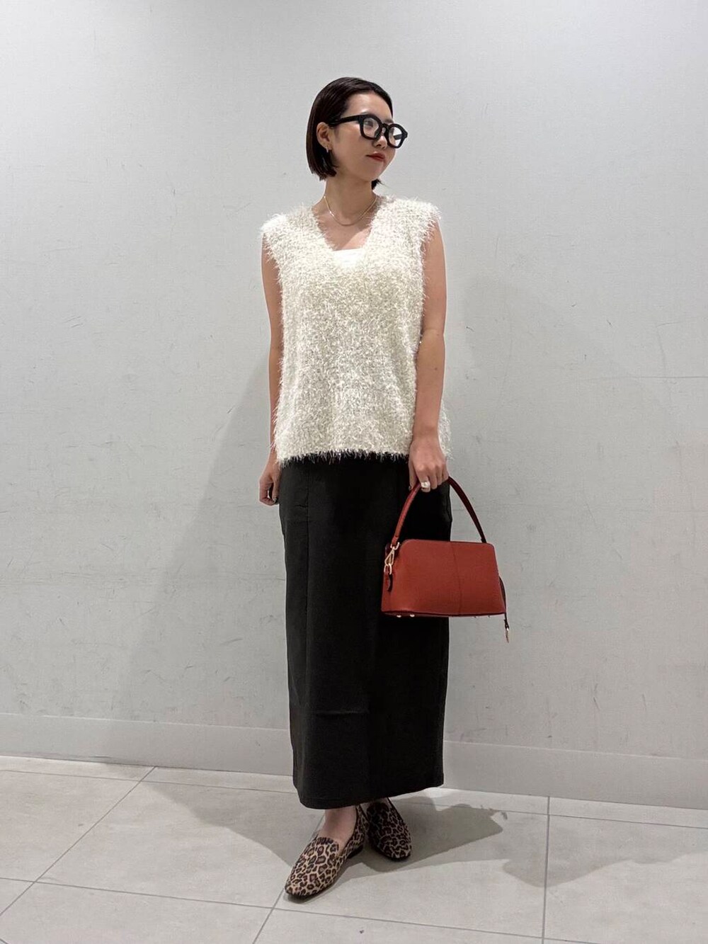 その他のローファー、ホワイト系のキャミソール、オレンジ系のショルダーバッグを着用したレディースの夏コーディネートの2枚目の写真