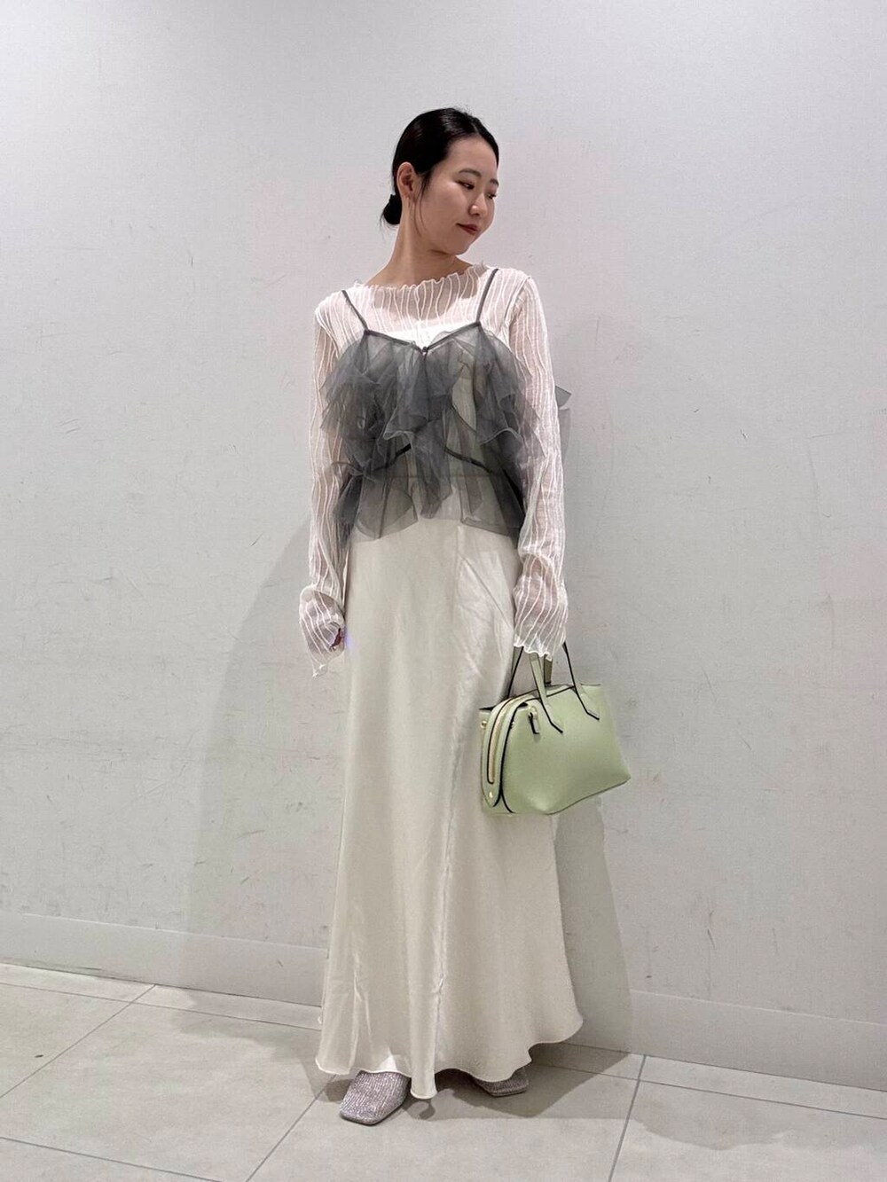 ホワイト系のスカート、ホワイト系のキャミソール、グレー系のその他トップスを着用したレディースの春コーディネートの2枚目の写真