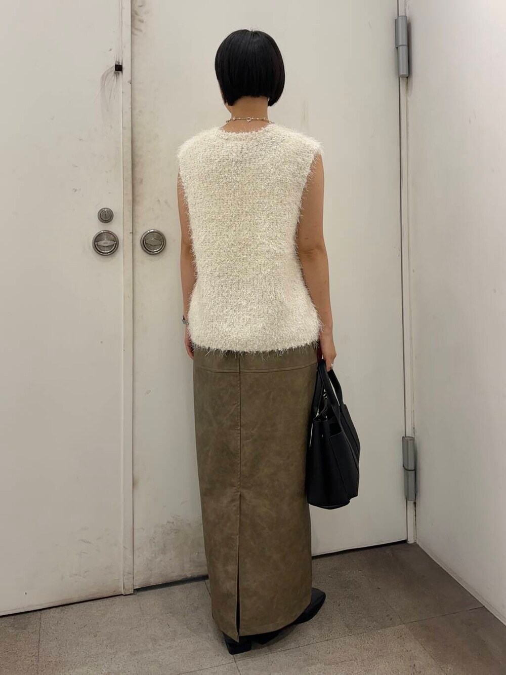 ブラック系のトートバッグ、レッド系のバレエシューズ、グリーン系のスカートを着用したレディースの秋コーディネートの4枚目の写真