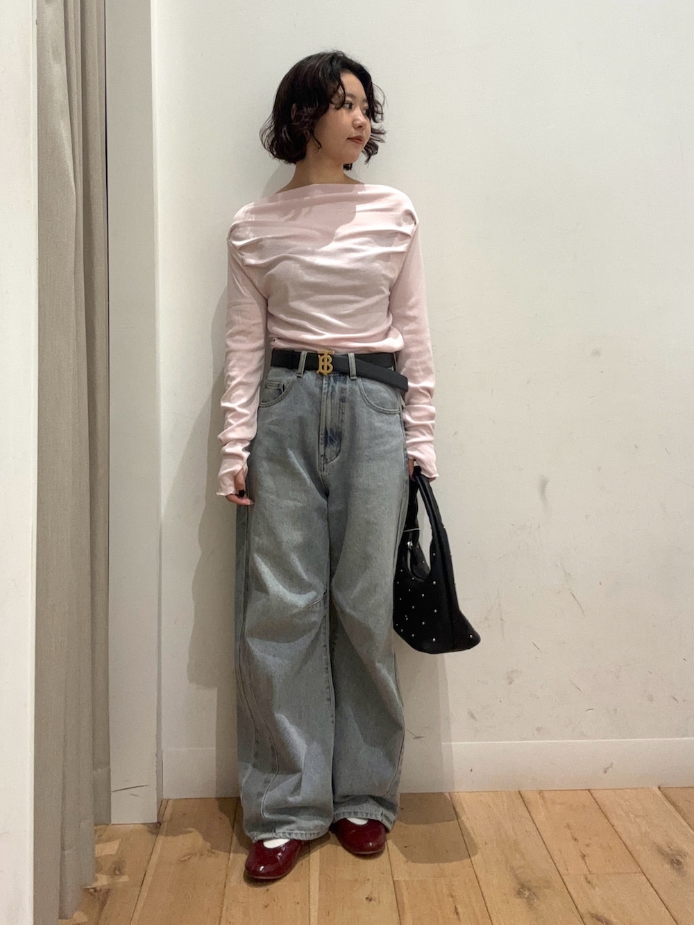 ピンク系のTシャツ/カットソー、ブルー系のデニムパンツ、ブラック系のハンドバッグを着用したレディースの冬コーディネートの3枚目の写真