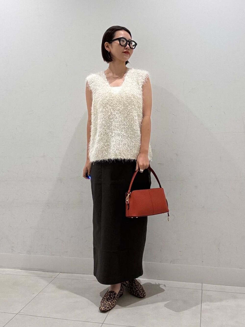 その他のローファー、ホワイト系のキャミソール、オレンジ系のショルダーバッグを着用したレディースの夏コーディネートの4枚目の写真