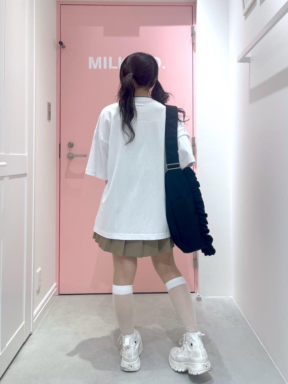 ブラック系のショルダーバッグ、ホワイト系のTシャツ/カットソー、イエロー系のカーディガン/ボレロを着用したレディースの春コーディネートの3枚目の写真