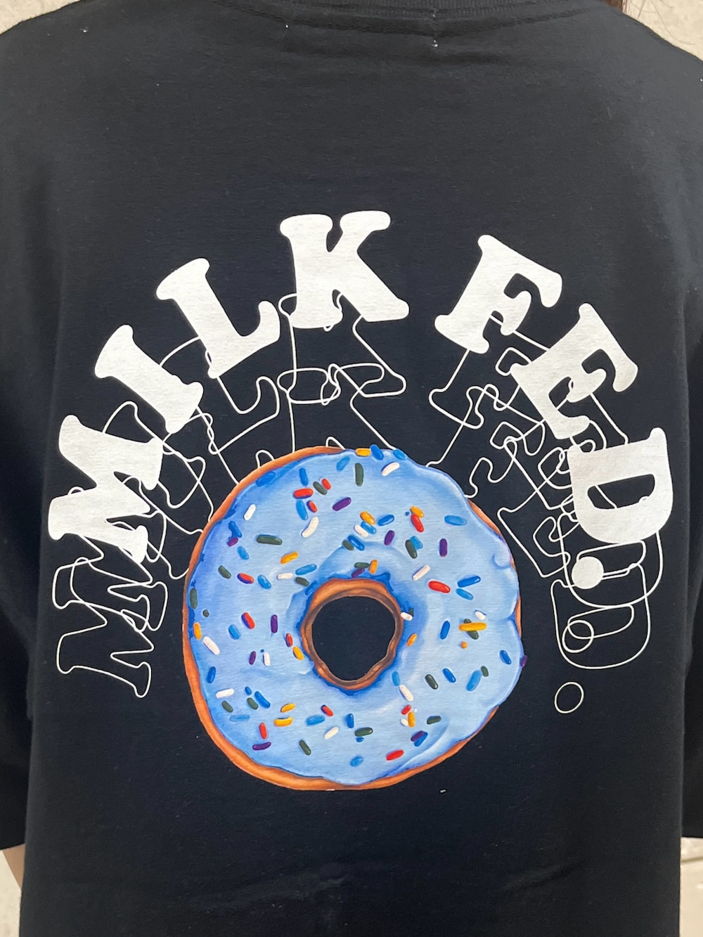 ブラック系のトートバッグ、ブルー系のデニムパンツ、ブラック系のTシャツ/カットソーを着用したレディースの春コーディネートの5枚目の写真