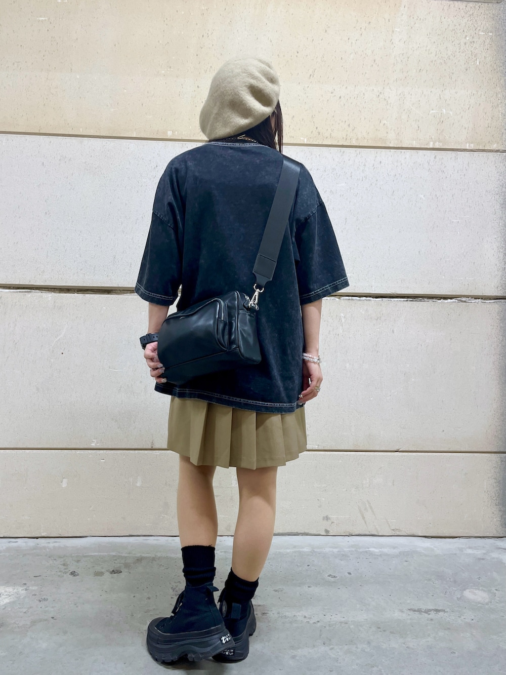 ベージュ系のスカート、グレー系のTシャツ/カットソー、ブラック系のショルダーバッグを着用したレディースの春コーディネートの3枚目の写真