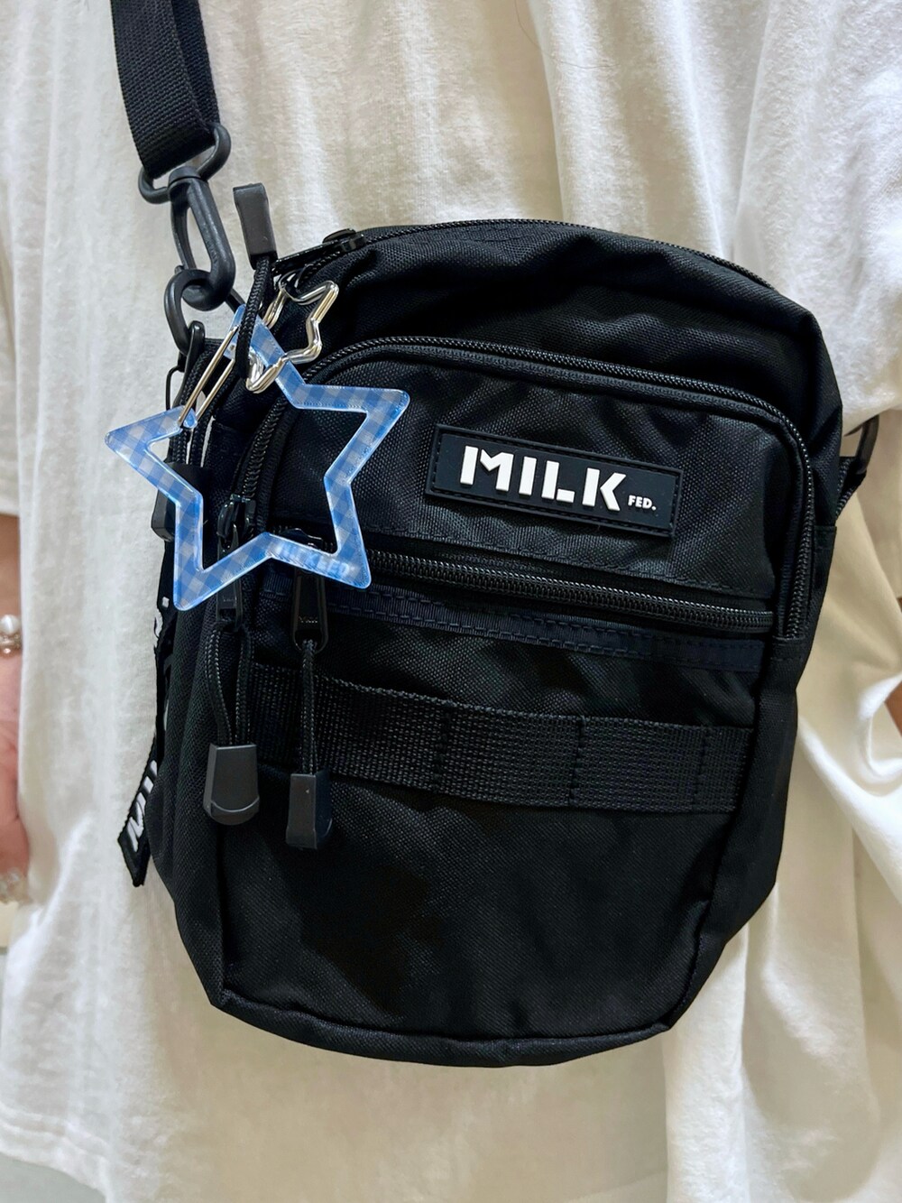 ブルー系のデニムパンツ、ブラック系のショルダーバッグ、ホワイト系のTシャツ/カットソーを着用したレディースの春コーディネートの5枚目の写真