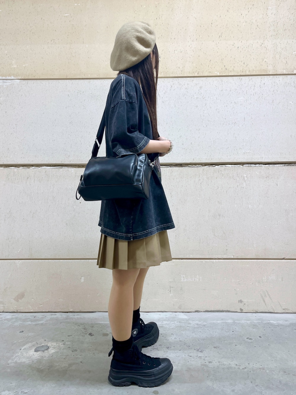 ベージュ系のスカート、グレー系のTシャツ/カットソー、ブラック系のショルダーバッグを着用したレディースの春コーディネートの2枚目の写真