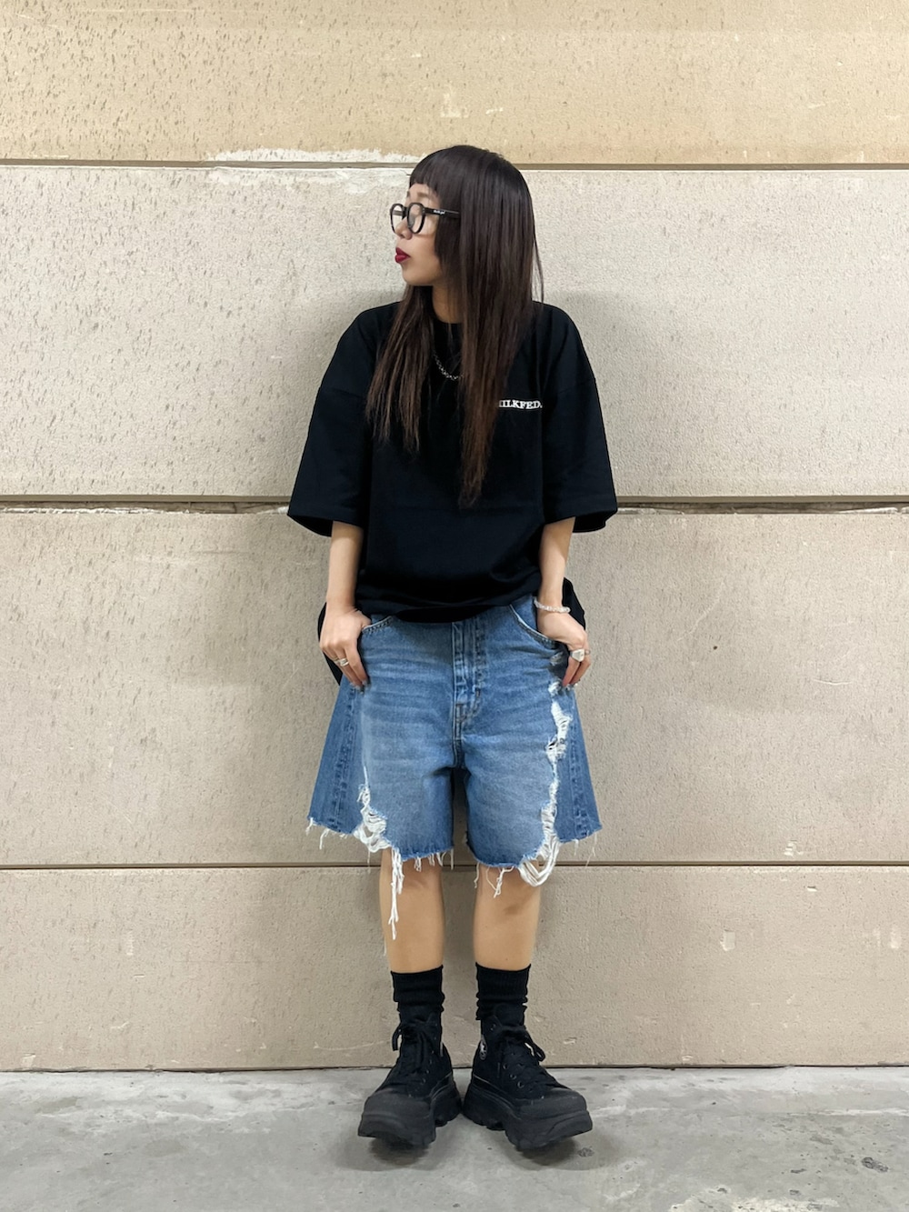 ブラック系のトートバッグ、ブルー系のデニムパンツ、ブラック系のTシャツ/カットソーを着用したレディースの春コーディネートの2枚目の写真