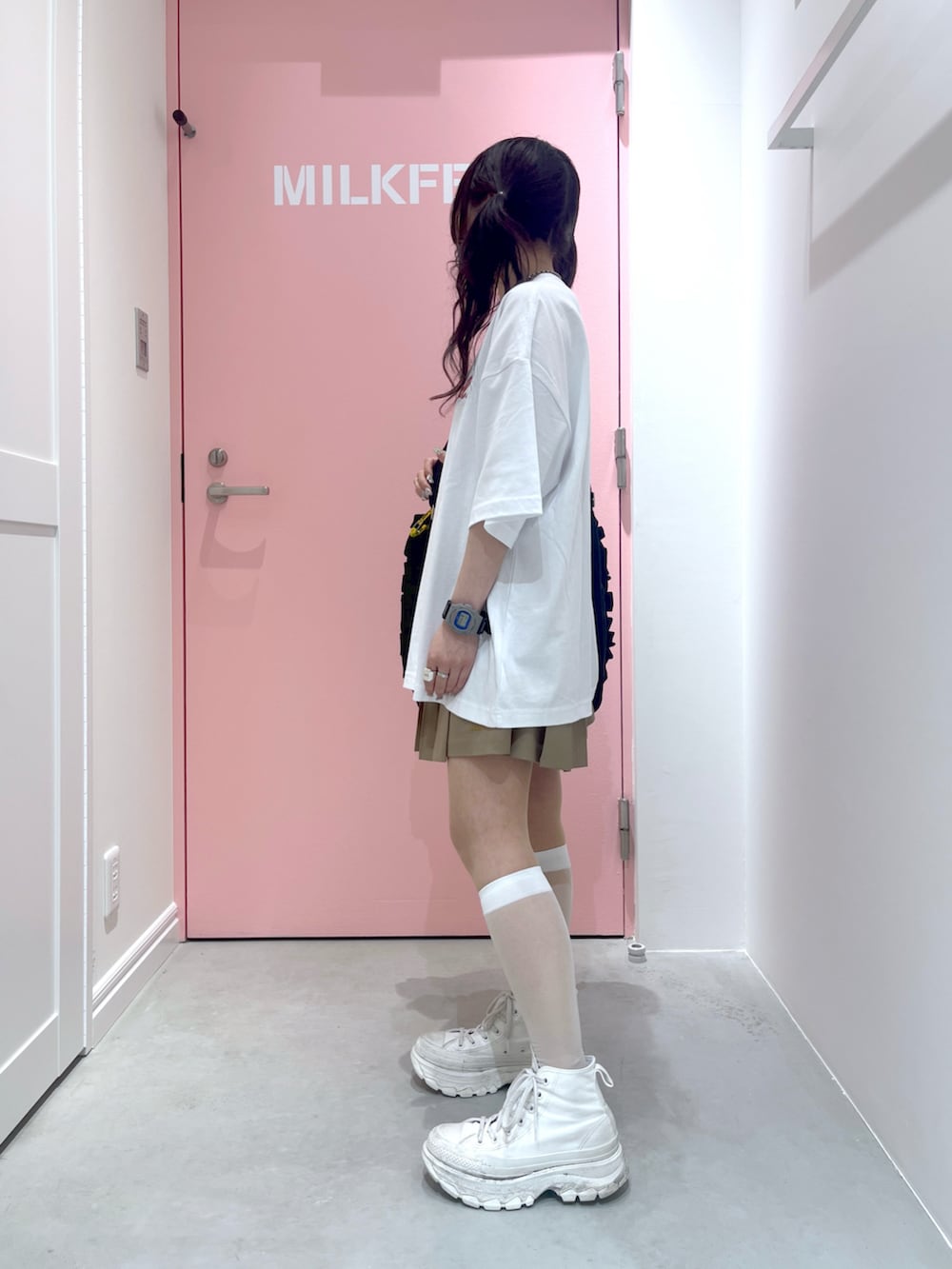 ブラック系のショルダーバッグ、ホワイト系のTシャツ/カットソー、イエロー系のカーディガン/ボレロを着用したレディースの春コーディネートの2枚目の写真