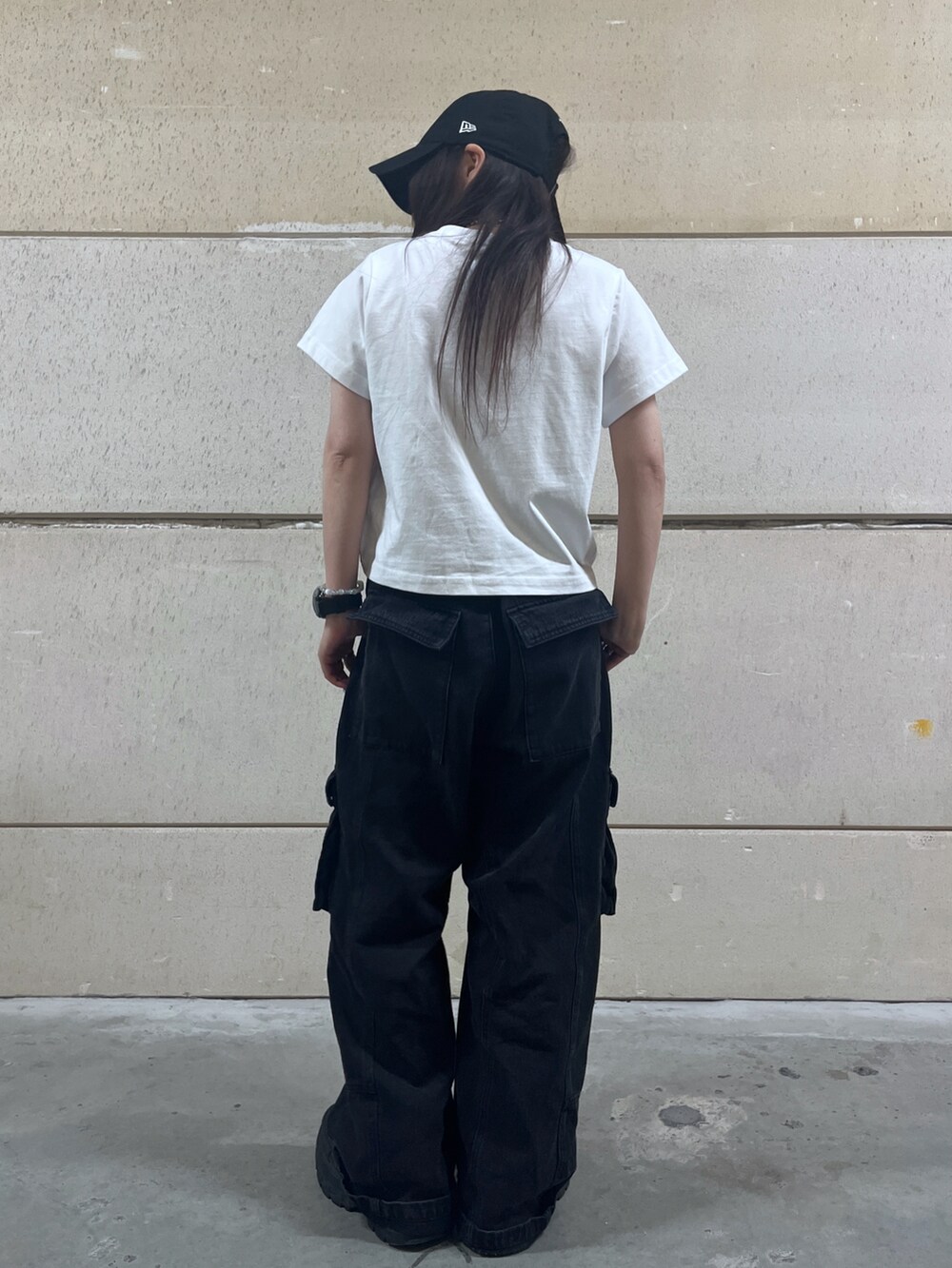ブラック系のカーゴパンツ、ホワイト系のTシャツ/カットソー、ブラック系のキャップを着用したレディースの春コーディネートの2枚目の写真