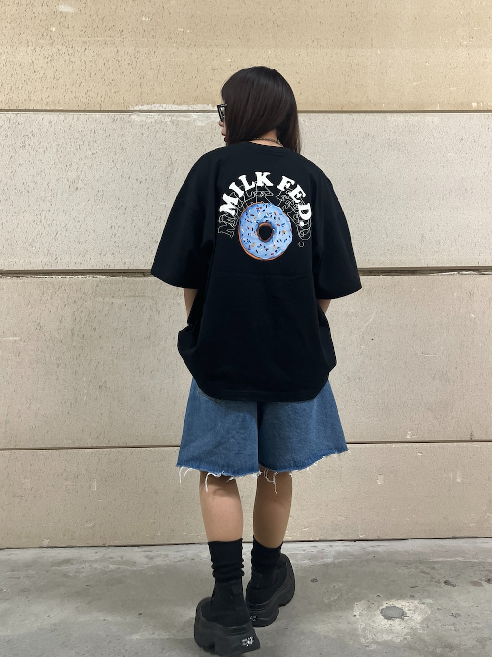 ブラック系のトートバッグ、ブルー系のデニムパンツ、ブラック系のTシャツ/カットソーを着用したレディースの春コーディネートの3枚目の写真