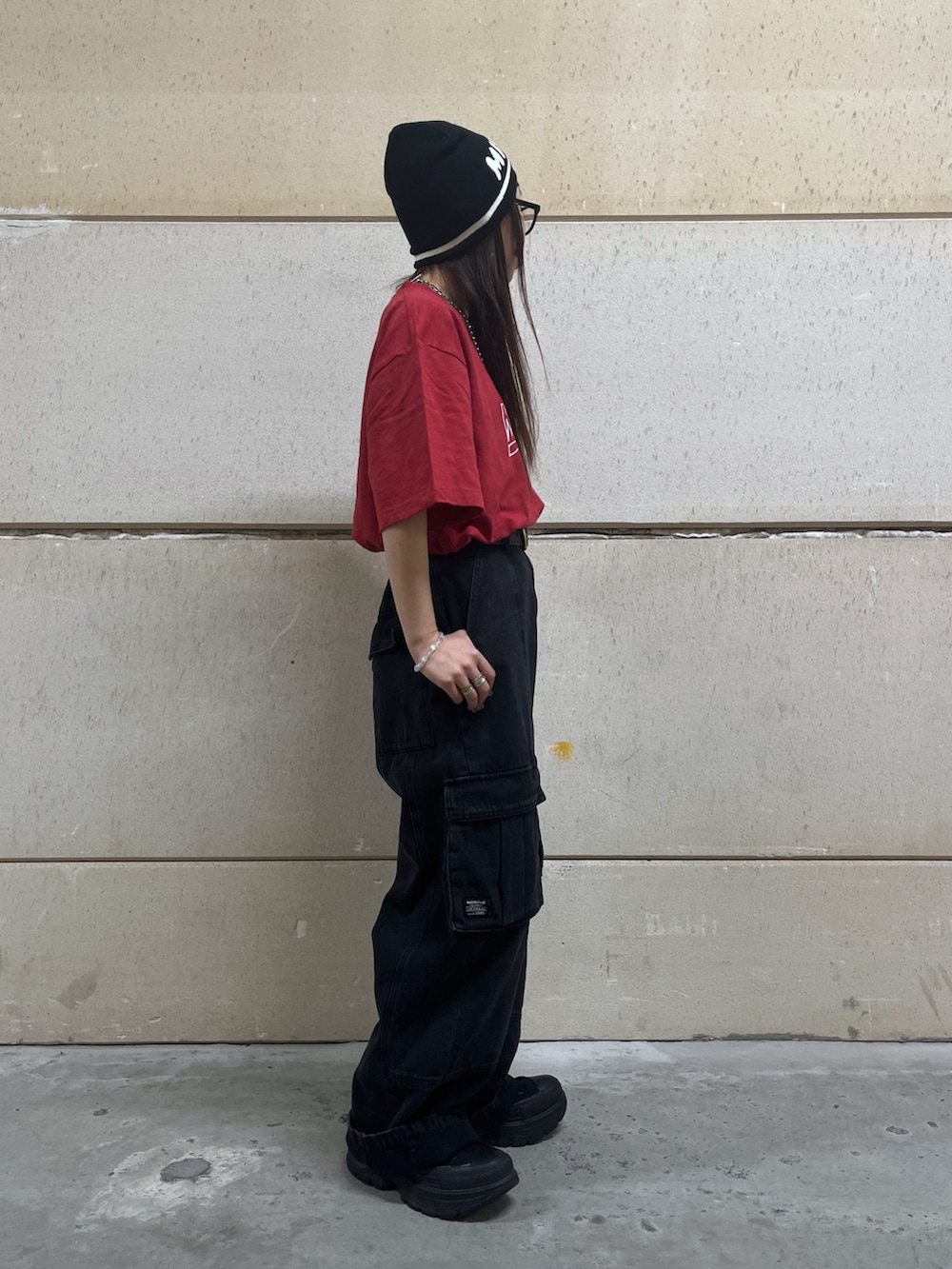 ブラック系のカーゴパンツ、レッド系のTシャツ/カットソー、ブラック系のニットキャップ/ビーニーを着用したレディースの春コーディネートの2枚目の写真