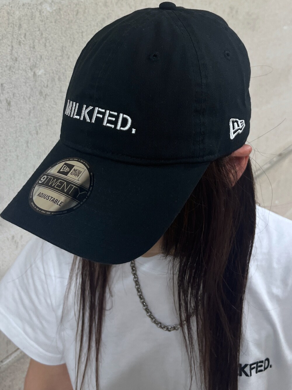 ブラック系のカーゴパンツ、ホワイト系のTシャツ/カットソー、ブラック系のキャップを着用したレディースの春コーディネートの4枚目の写真