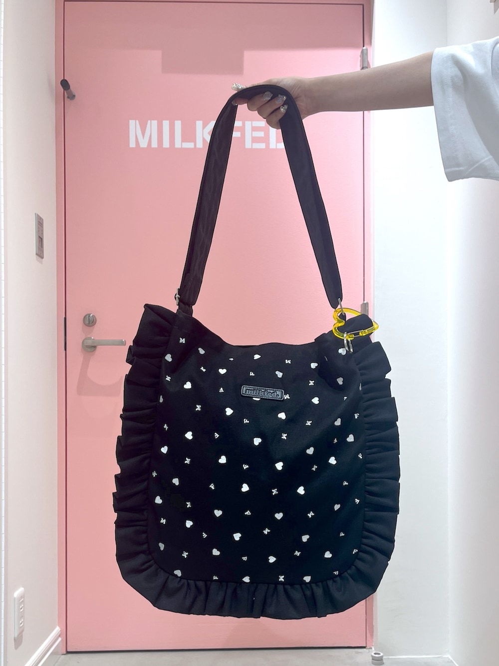 ブラック系のショルダーバッグ、ホワイト系のTシャツ/カットソー、イエロー系のカーディガン/ボレロを着用したレディースの春コーディネートの4枚目の写真