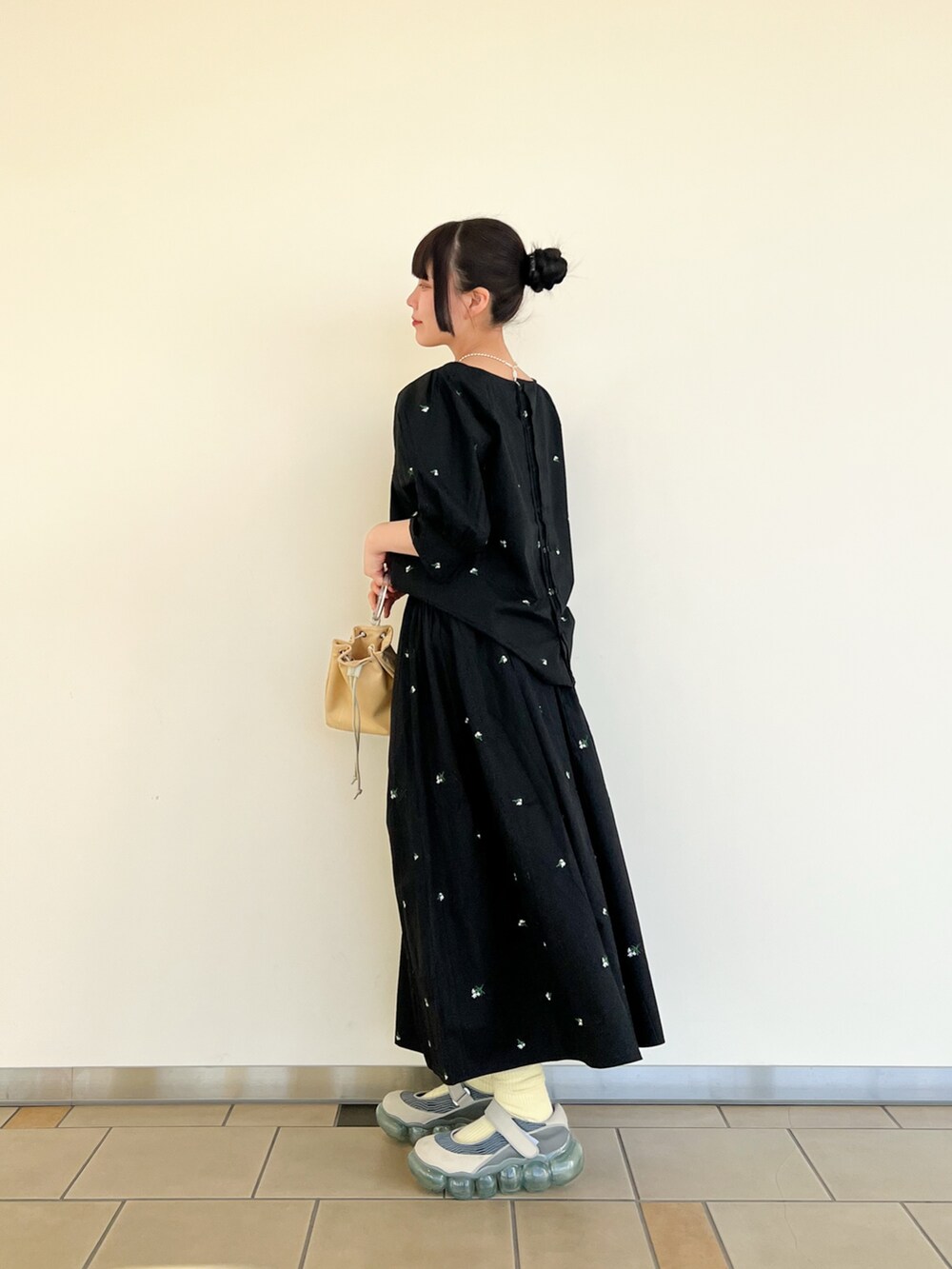 ブラック系のシャツ/ブラウス、ブラック系のスカート、イエロー系のショルダーバッグを着用したレディースの春コーディネートの3枚目の写真