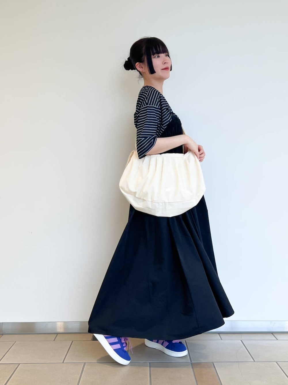 ホワイト系のショルダーバッグ、ブラック系のワンピース、ブルー系のTシャツ/カットソーを着用したレディースの夏コーディネートの2枚目の写真