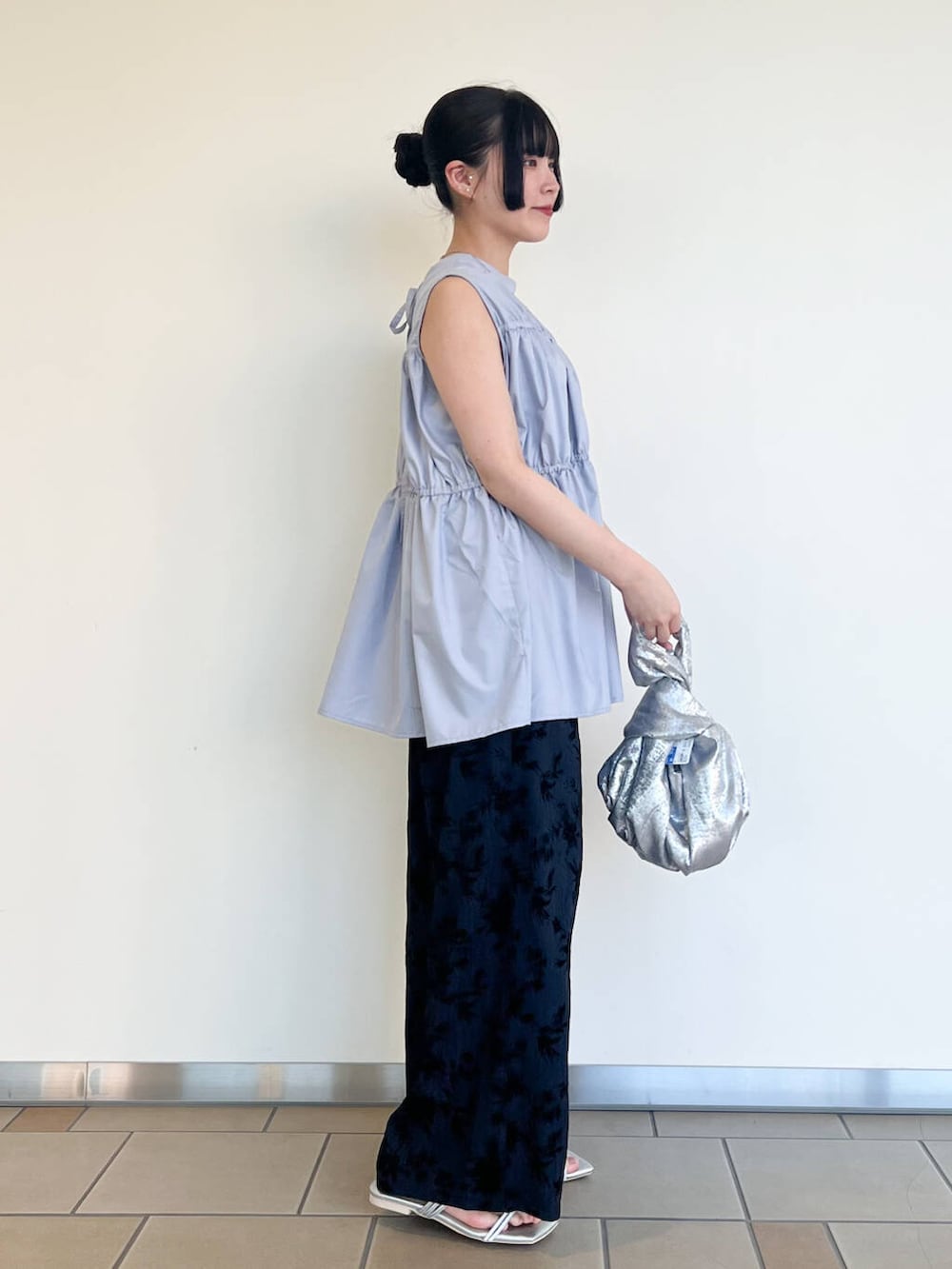 シルバー系のハンドバッグ、シルバー系のサンダル、ブルー系のその他パンツを着用したレディースの夏コーディネートの2枚目の写真