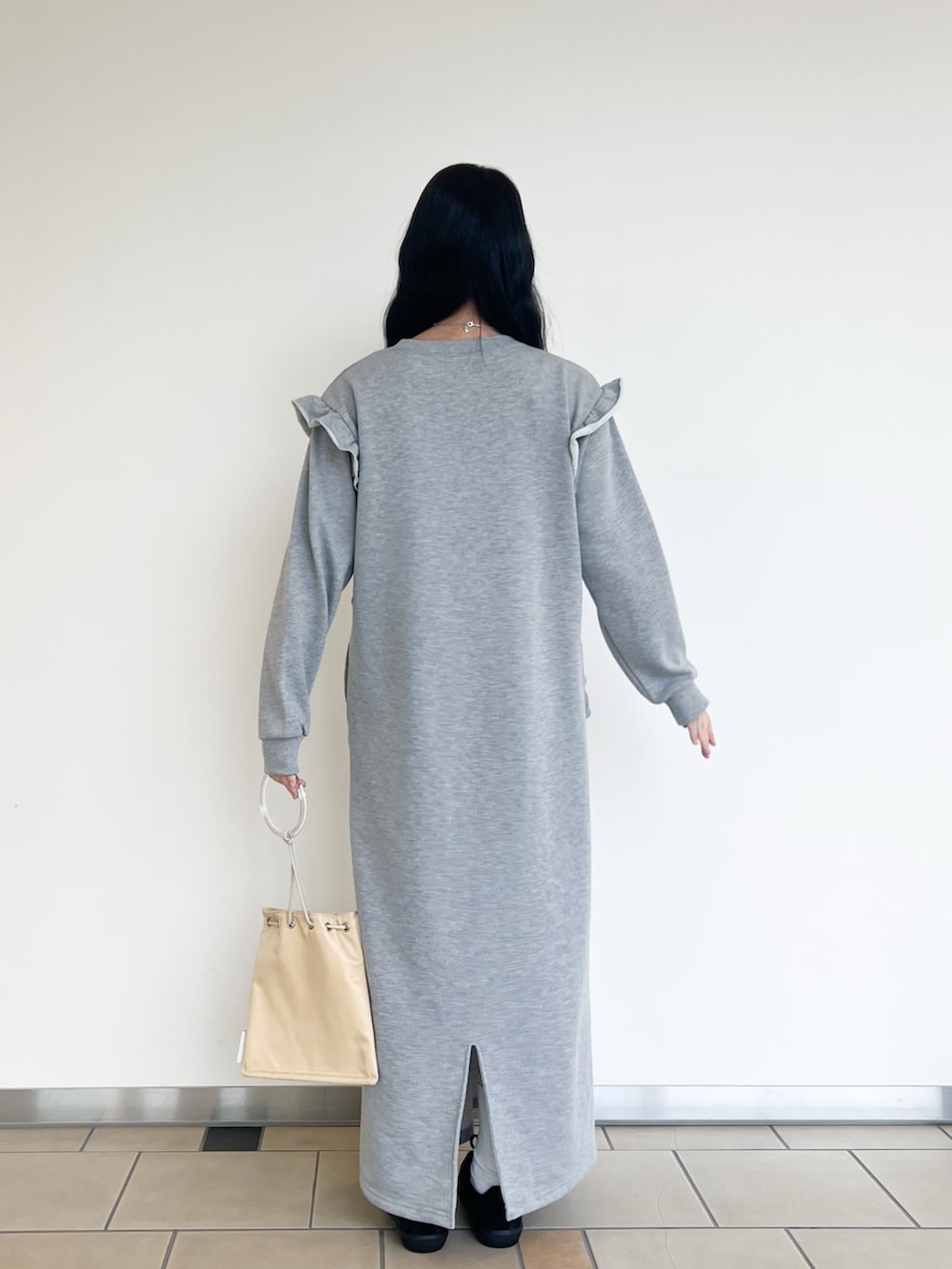 ブラック系のスニーカー、グレー系のワンピース、イエロー系のショルダーバッグを着用したレディースの春コーディネートの3枚目の写真