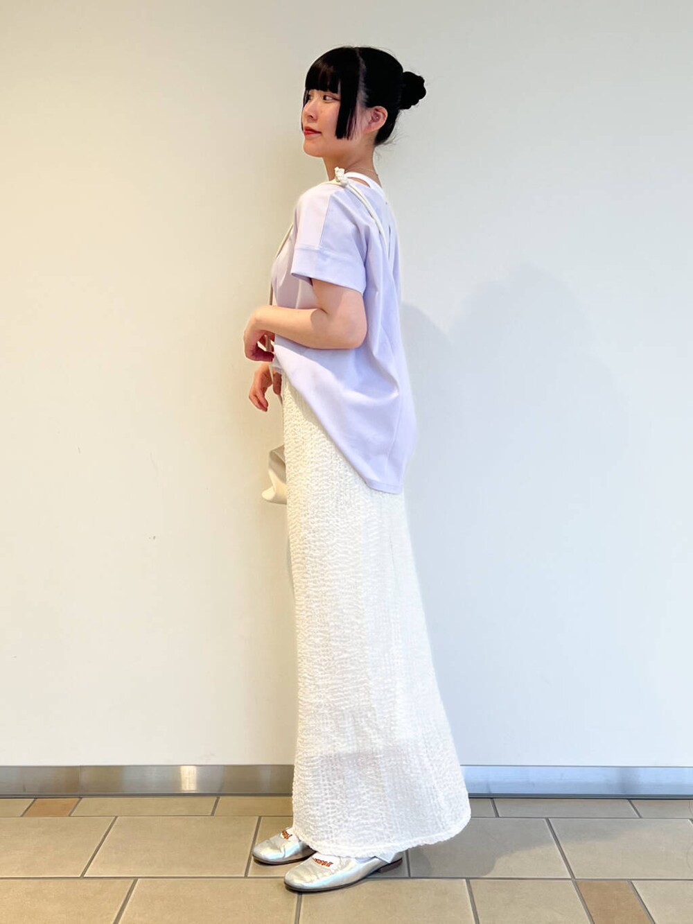 ホワイト系のショルダーバッグ、パープル系のTシャツ/カットソー、ホワイト系のスカートを着用したレディースの夏コーディネートの2枚目の写真
